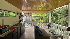Una cocina moderna con comedor, sofá y balcón con barandillas blancas.