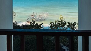A view from a balcony overlooking a beach with calm waters and a clear sky. - Chic Loft Steps from the Jungle View (Holbox)