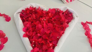 A neatly made bed with a heart-shaped arrangement of red flowers and two towels shaped like swans. - Swarnapaya résidence (Bentota)