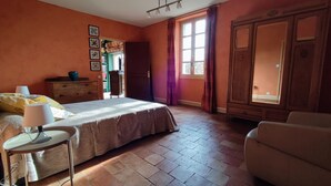 Un dormitorio con cama, cómoda, silla y armario.