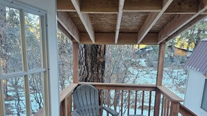 A wooden deck with a chair and table, a wooden railing, and a view of a snowy landscape. - Cuatros Pinos ~ Quiet Tall Pine Retreat (Durango)