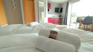 A hotel room with a bed, a bathroom, a kitchenette, and a balcony. - Boardinghouse Kappeln by Team SchleiFee (Kappeln)