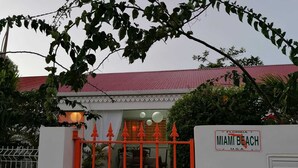 A gated entrance to a building with a red roof and a sign indicating Miami Beach, Florida. - Creole vacation home 15 minutes from the beach and 5 minutes from downtown! (Rivière-Salée)