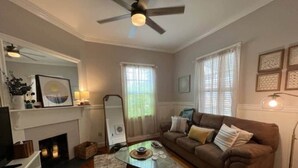 A living room with a fireplace, a sofa, a coffee table, and a television. - Relaxing Poolside Condo (Savannah)
