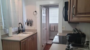 A compact kitchen with a sink, countertop, and a coffee maker. - Relaxing Poolside Condo (Savannah)