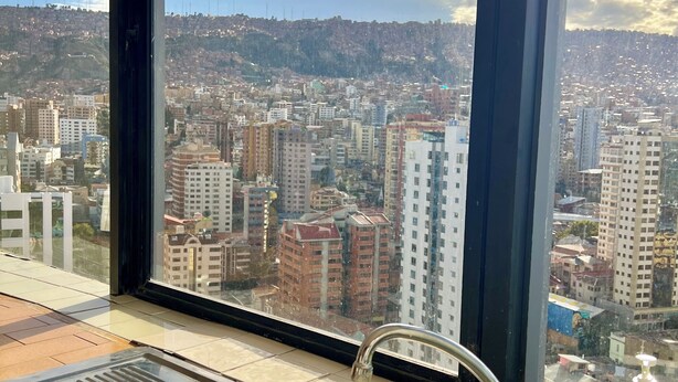A kitchen with a stainless steel sink and a window overlooking a cityscape. - Central Apartment with Stunning Views in La Paz (La Paz)