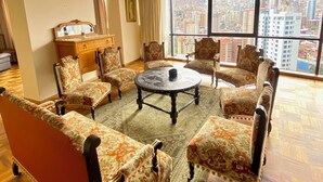 A spacious living room with a large city view, a round coffee table, and patterned armchairs. - Central Apartment with Stunning Views in La Paz (La Paz)