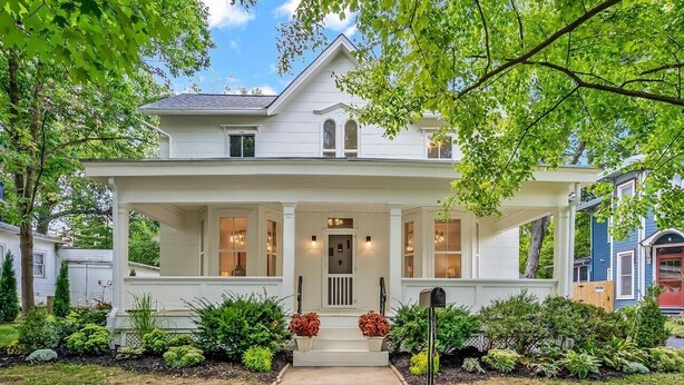 A two-story house with a front porch, a mailbox, and a well-maintained garden. - Charming Historic Home, Luxurious Remodel, Walk to Downtown, Tree-Lined Street (Delaware)