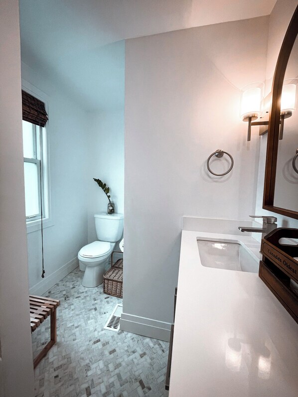 A bathroom with a toilet, bidet, and a sink with a mirror.