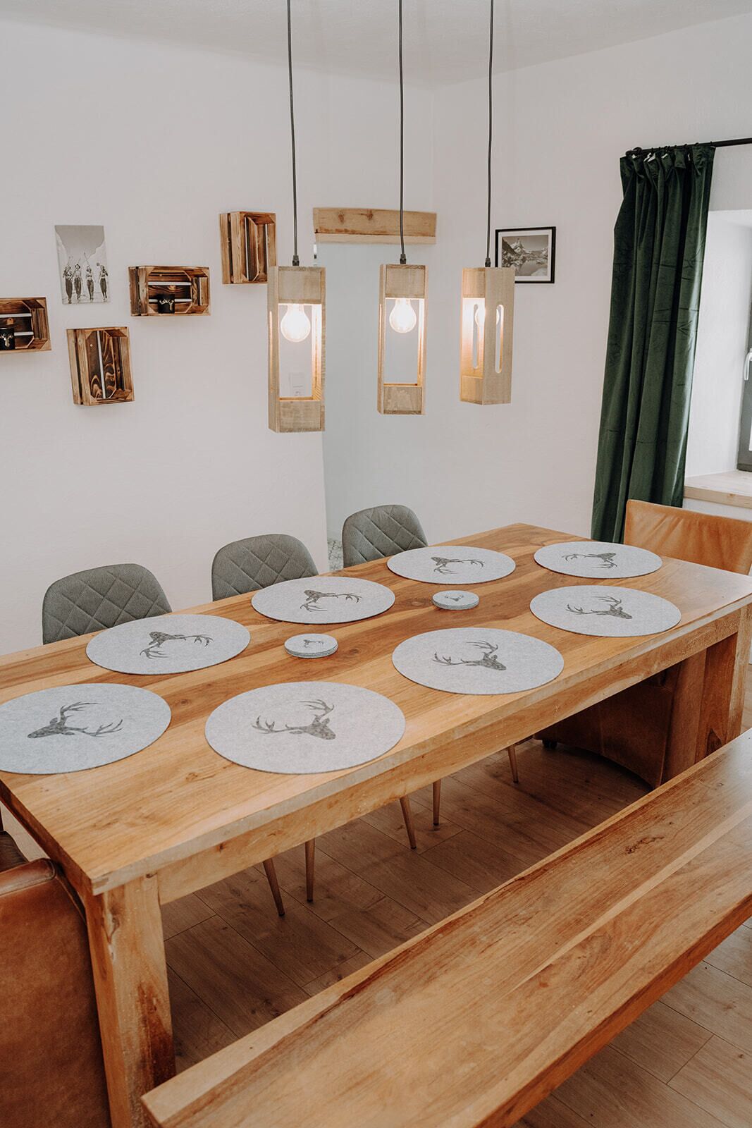 A dining area with a wooden table set for six, featuring round placemats with deer designs.