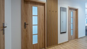 Un couloir avec des portes en bois et un panneau de bois vertical.