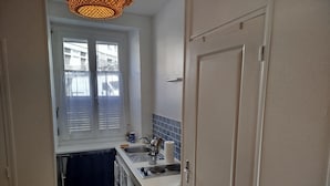 Una cocina compacta con ventana, un lavamanos y una estufa.