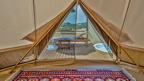 Una carpa con una plataforma de madera, una mesa y una silla.
