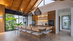 Una cocina moderna con una isla grande, techo de madera y lámparas colgantes.