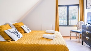 A hotel room with a bed, a chair, a dresser, and a window with curtains. - Les Longères de Montfranc (Pierrefitte-sur-Sauldre)