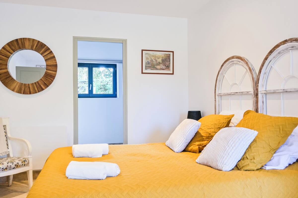 Une chambre à coucher avec un lit, une chaise, une porte et une fenêtre.