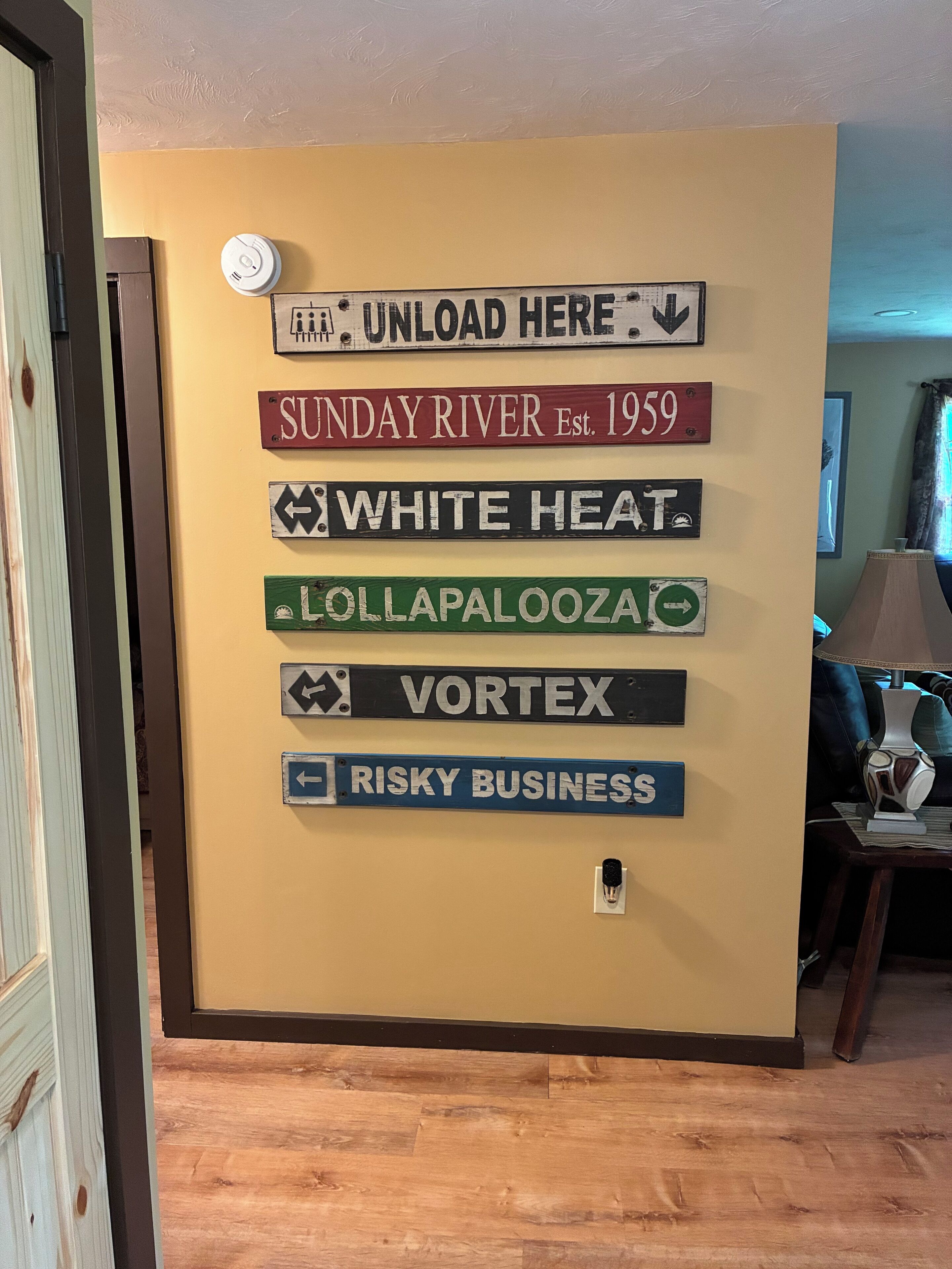 Un mur orné de différents panneaux, notamment « Sunday River, fondé en 1959 », « White Heat », « Lollapalooza », « Vortex » et « Risky Business ».