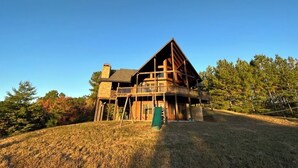 A large wooden cabin with a balcony, surrounded by trees and a grassy area. - Gorgeous Cabin Private Retreat on 15 acres (Copperhill)