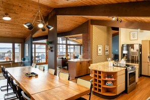 A modern kitchen with a wooden ceiling, a central island, and a refrigerator. - Lakefront Lake Anna Views, Dock, Hot Tub, Firepit (Bumpass)