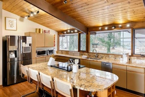 A modern kitchen with granite countertops, stainless steel appliances, and a large island with seating.