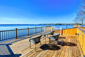 En træterrasse med udendørs møbler med udsigt over vandet.