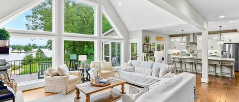 A spacious living area with a large window, a kitchen, and a dining area.