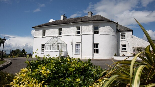A white, two-story house with a conservatory and a curved roof. - Hill House – Luxury Group Getaway with Stunning Views, Sleeps 17 (Cashel)