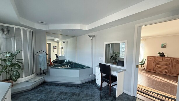 A modern bathroom with a freestanding bathtub, a vanity with a mirror, and a shower area. - Large private bungalow in Lévis (Saint-Nicolas)