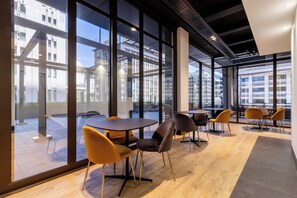 Enjoy city views from large windows in this stylish space with a unique table and chair arrangement.