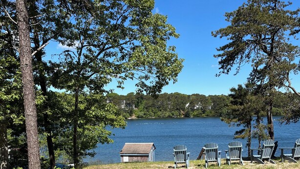 A lakeside view with a small dock, several Adirondack chairs, and a cabin. - New listing! Cozy, fresh and clean 1-bedroom cottage with Pond access in Chatham (Chatham)