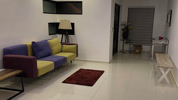 Un salon moderne avec un canapé, une table basse et un téléviseur fixé au mur.