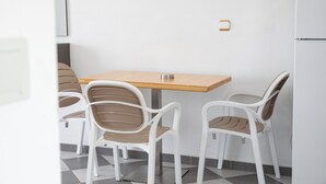 Ein kleiner Essbereich mit einem Holztisch und weißen Stühlen.