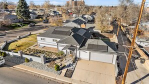 Ett bostadsområde med hus, en gata och en stor byggnad i bakgrunden.