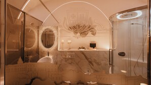 A luxurious bathroom with a marble sink, a large mirror, and a shower area. - Tower of Bassano Luxury Room (Vasto)
