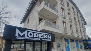 Un edificio moderno con un letrero que dice "MODERN" y un número de contacto.