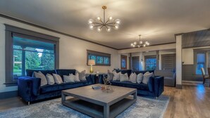 Un ampio soggiorno con un'ampia sezione divaneria, un tavolino da caffè e un lampadario.
