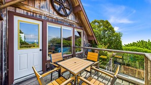 Ein Holzhaus mit Balkon, großen Fenstern und einer Tür.