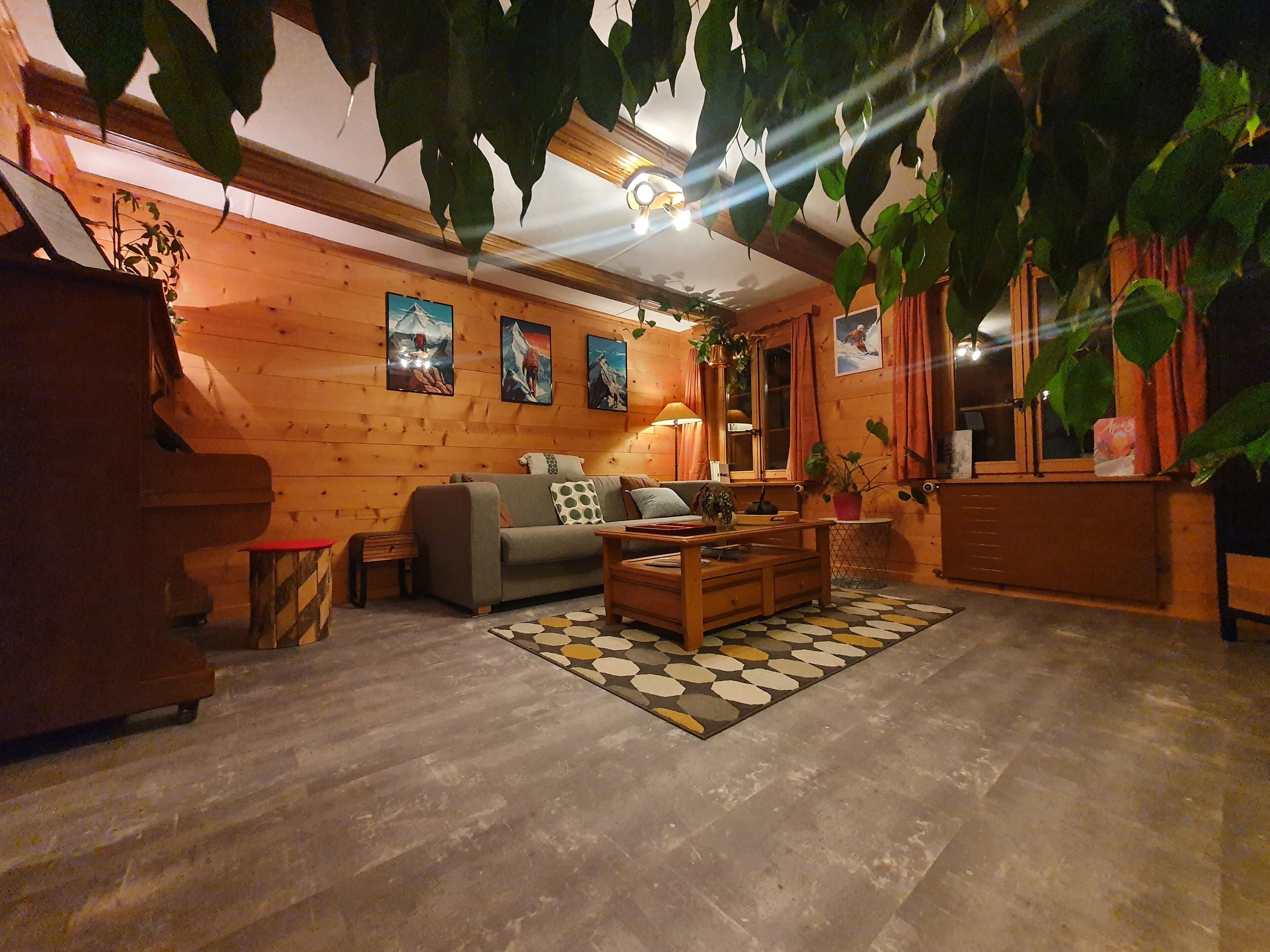 A cozy living room with wooden walls, a sofa, a coffee table, and a rug. - Chalet le muveran, in the center of gryon with garden! (Gryon)