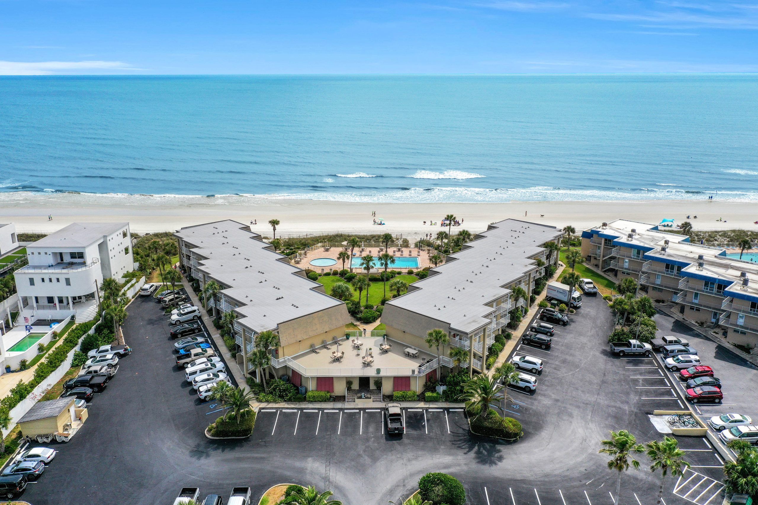 Un hôtel doté d’une cour intérieure, d’une piscine et offrant une vue sur la plage.