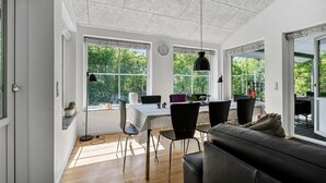 Ein moderner Essbereich mit Tisch für vier Personen, umgeben von schwarzen Stühlen, unter einer Decke mit markanter Struktur.