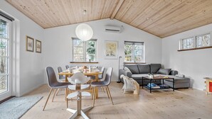 A spacious living area with a dining table, grey sofas, and a wooden ceiling. - Stunning home in Holbæk with sauna (Holbæk)