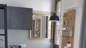 Una cocina moderna con una mesa y sillas de madera, un lavamanos y un espejo.
