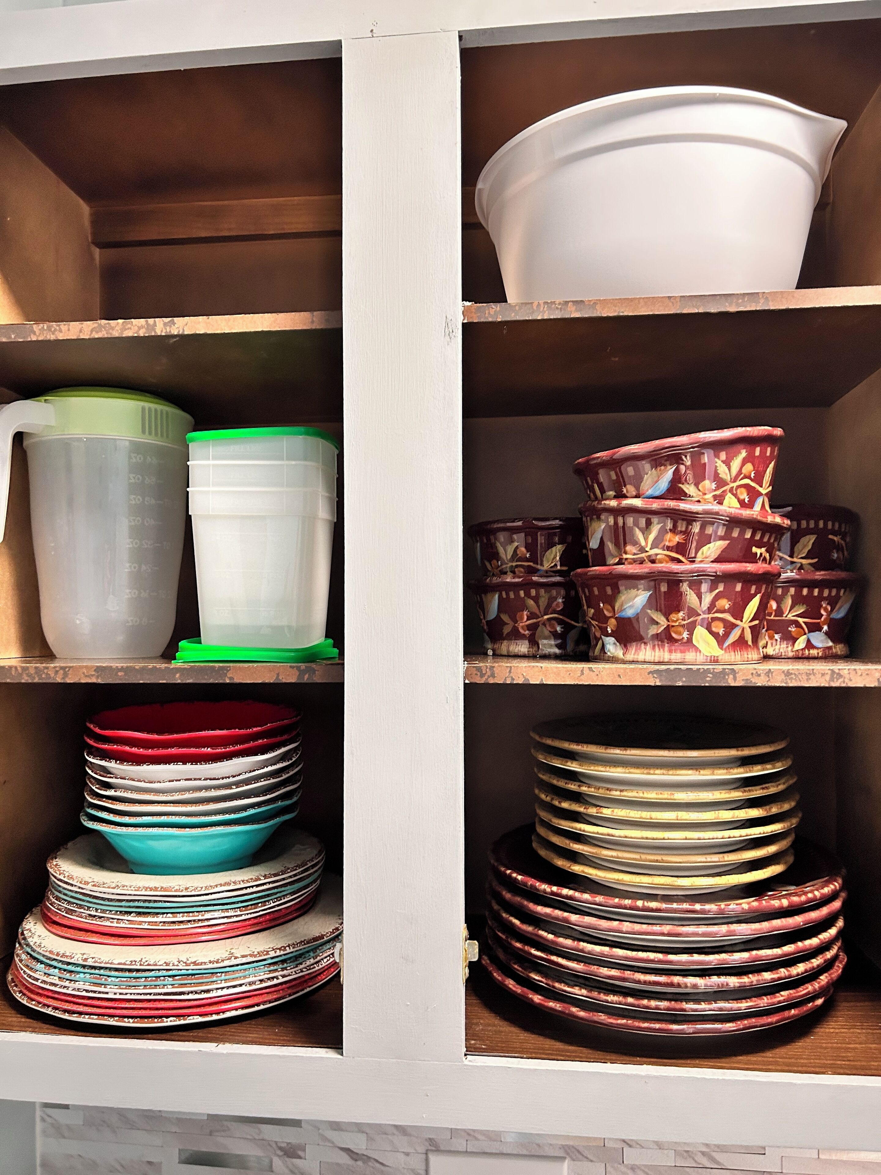 A kitchen cabinet with various kitchenware items.