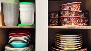 A kitchen cabinet with various kitchenware items.