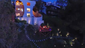 A modern house with a unique architectural design, featuring multiple levels and a curved structure.