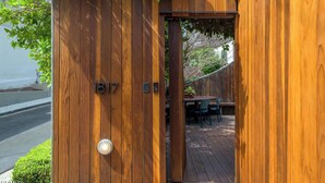 A wooden gate with the number 817, leading to a patio area with a table and chairs.
