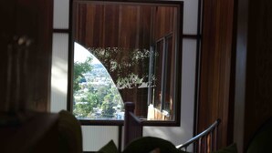 A room with a large window offering a view of a hillside.