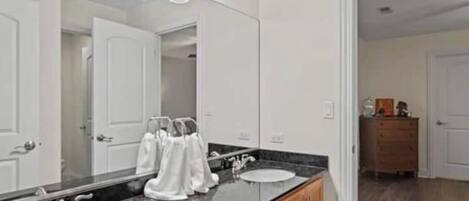 Un baño moderno con dos lavamanos, un espejo grande y un mueble de tocador con armarios.