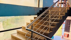 A staircase with metal railings and a blue wall. - Blue Rocks Suites, Sarjapur Road (Bengaluru)