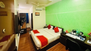 A hotel room with a bed, a desk with a telephone, and a mirror. - Blue Rocks Suites, Sarjapur Road (Bengaluru)